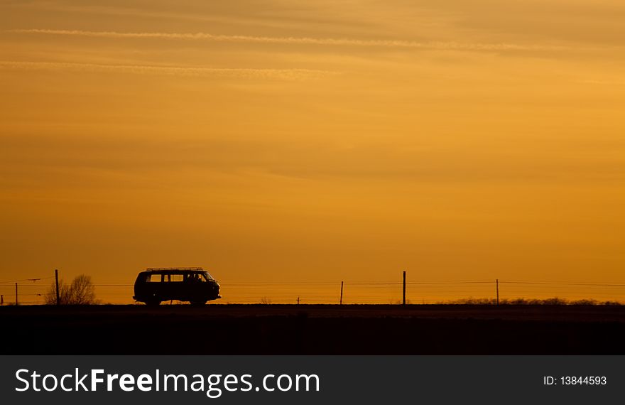 Car silhouette on the road in the sunset