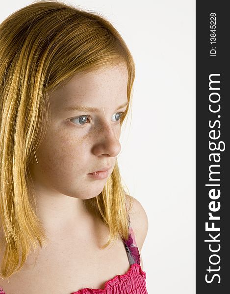 Sad looking redhead girl isolated on a white background