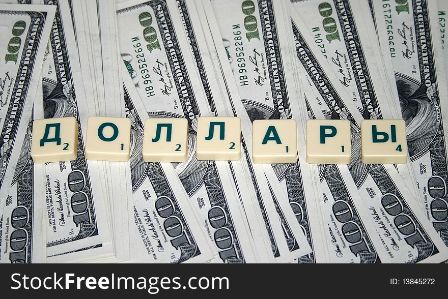 A bundle of money with denominations of one hundred dollars and an inscription in Russian dollars