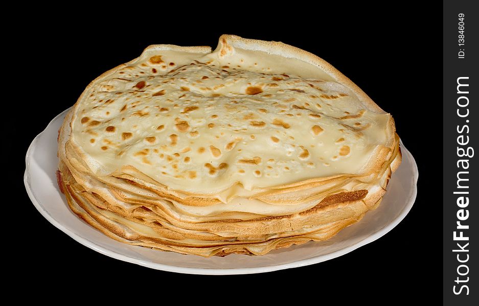 Pancakes on a white dish and on a black background