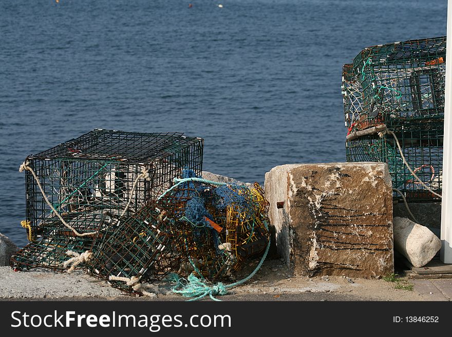 Old discarded lobster traps sit abandoned by the ocean side waiting to be picked up