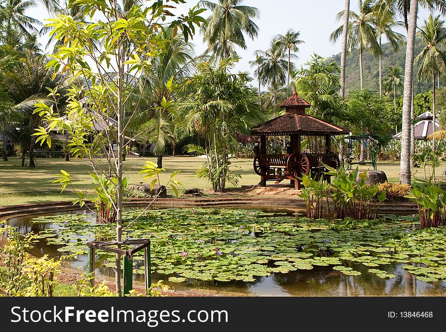 Wooden arbour and pond with flower. Thailand.