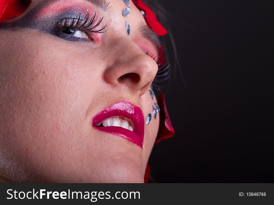 Young fresh woman with an extreme and glamorous makeup and roses on her face. Young fresh woman with an extreme and glamorous makeup and roses on her face.