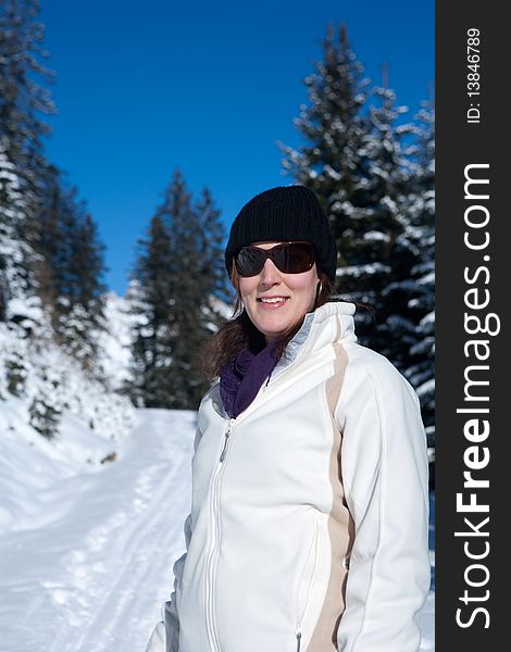 A young woman in a winter wonderland. Lot of snow and trees in the blury background. A young woman in a winter wonderland. Lot of snow and trees in the blury background.