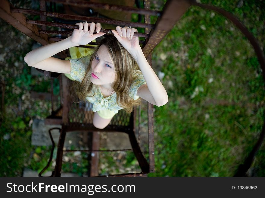 Top view of a young woman standing on a ladder. Top view of a young woman standing on a ladder