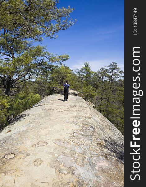 Tourist walking on the top natural bridge in Kentucky. Photo includes vandalism done by different kind of morons writing names on the rock. Tourist walking on the top natural bridge in Kentucky. Photo includes vandalism done by different kind of morons writing names on the rock.