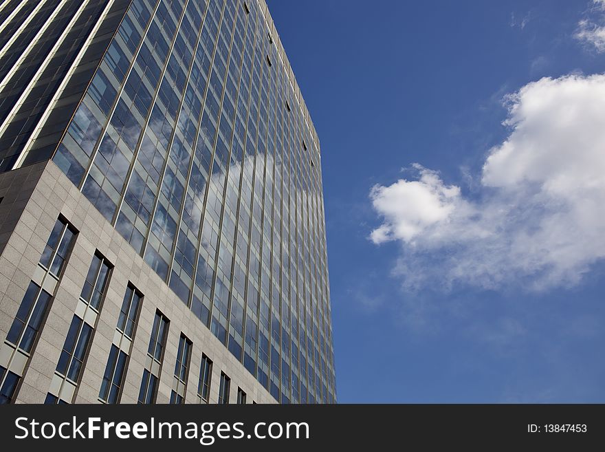 The modern office building on blue sky and white clouds background. The modern office building on blue sky and white clouds background