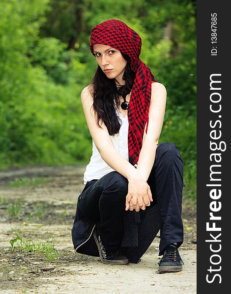 Girl sitting in the forest, on his head wearing a red kerchief. Girl sitting in the forest, on his head wearing a red kerchief
