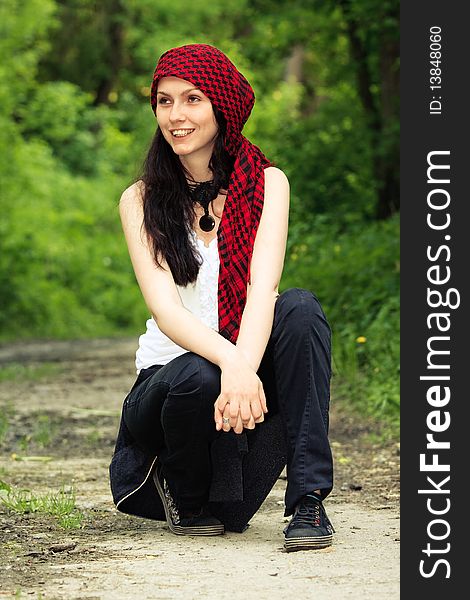 Girl sitting in the forest, on his head wearing a red kerchief. Girl sitting in the forest, on his head wearing a red kerchief