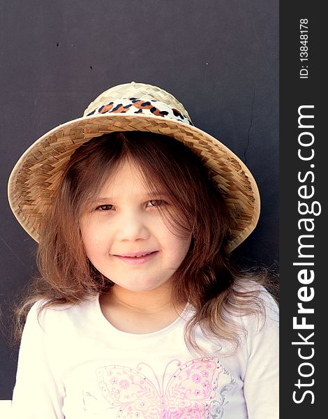Happy little girl wearing straw hat and white blouse, copy space available
