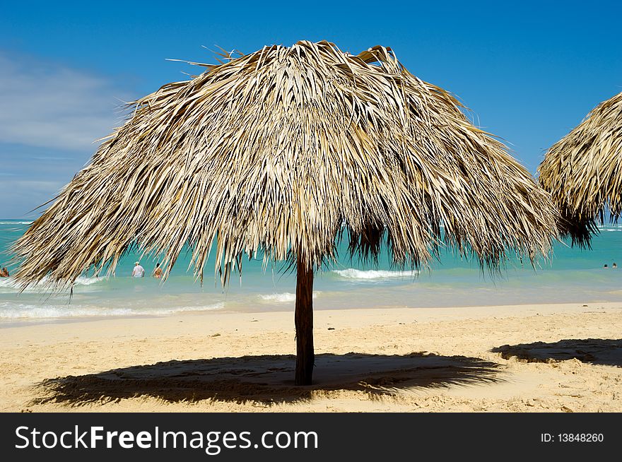 Parasol made out of palm leafs on beach.