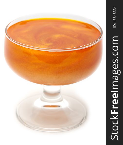 Orange mother-of-pearl jelly in transparent glass on white background