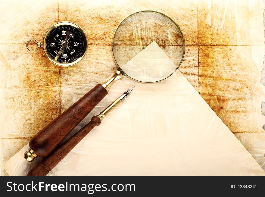 Compass and magnifier on old textured paper