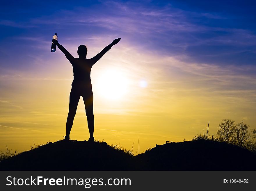 Athletic woman in the sunset happy in the hands of mineral water. Athletic woman in the sunset happy in the hands of mineral water.