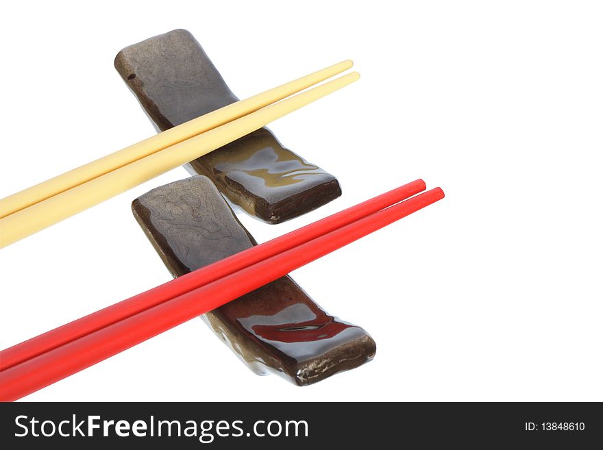 Two pair of colored chopsticks lying on rests. Isolated on white with clipping path