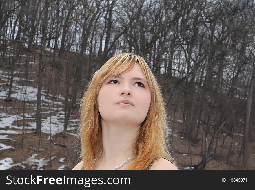 Beautiful blonde girl in the winter forest