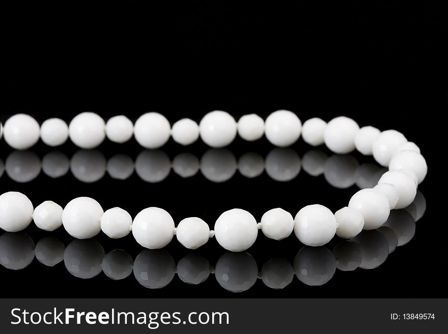 White beads on black background