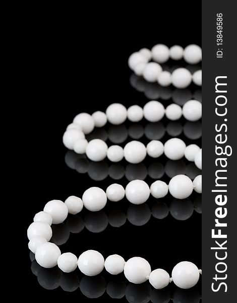 White beads on black background