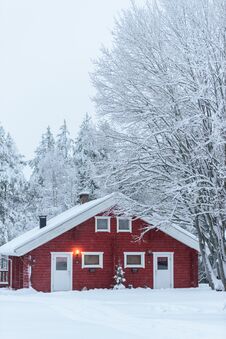 The House In The Forest Has Covered With Heavy Snow And Bad Sky In Winter Season At Holiday Village Kuukiuru, Finland Royalty Free Stock Photo