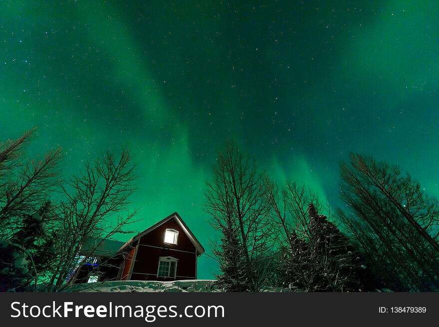 The northern lights Aurora Borealis at Kuukiuru village lake in Lapland, Finland