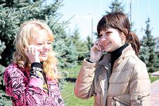 Two Girls Call By Phone In A Park Stock Images