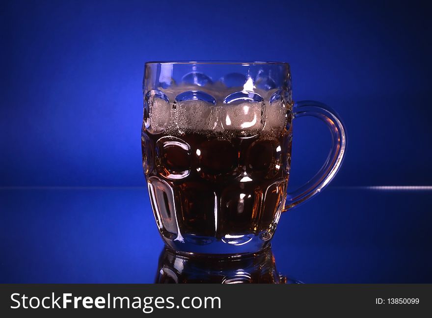 A glass of beer isolated on blue background