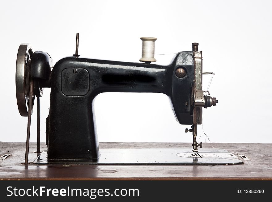 Old black sewing machine on white background