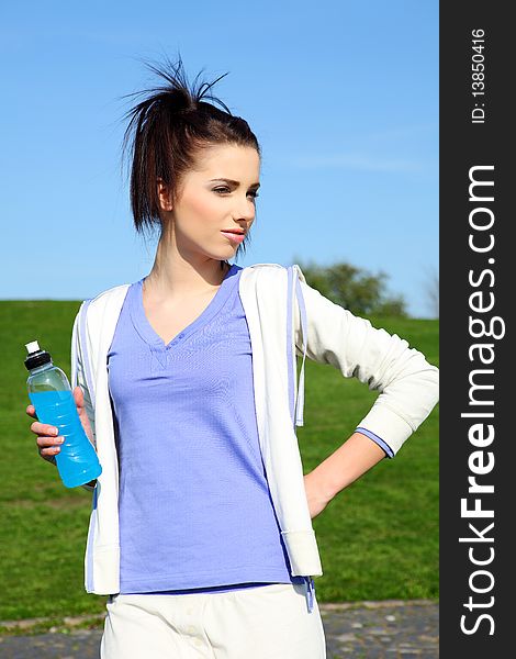 Young woman drinking water at outdoors workout