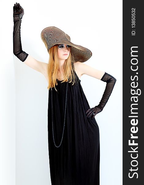 Portrait of a beautiful girl in elegant black dress and a  hat. Portrait of a beautiful girl in elegant black dress and a  hat.