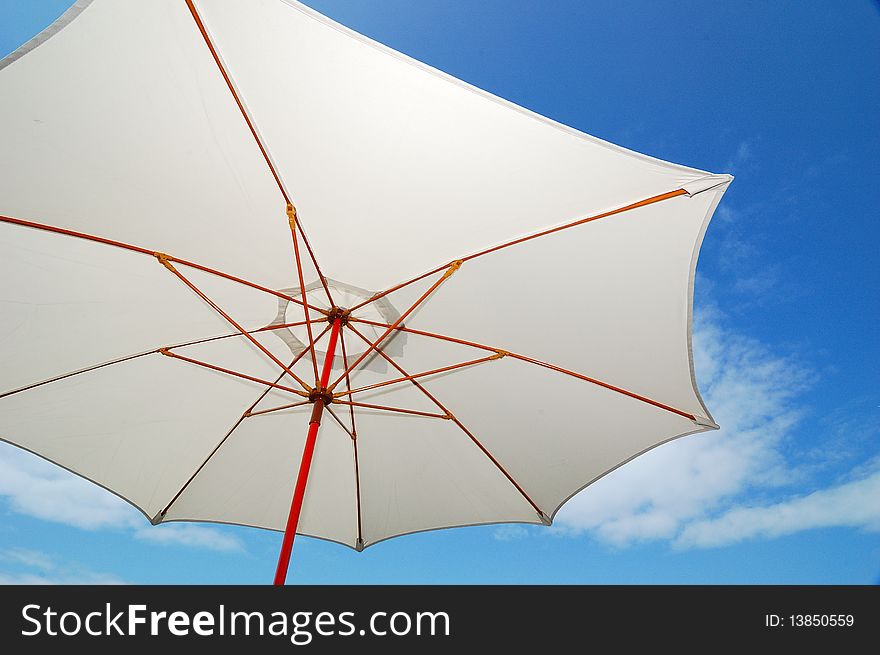 A big sunshade. Blue sky and white cloud background