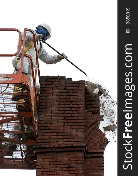 Frank (model release) wearing protective clothing and hardhat, during demolition of an old 1888 brick building by hand because of the integrity of the structure corner could collapse. Heavy Construction with bucket lift. Frank (model release) wearing protective clothing and hardhat, during demolition of an old 1888 brick building by hand because of the integrity of the structure corner could collapse. Heavy Construction with bucket lift.