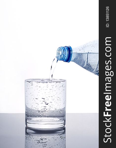 Glass of water being filled from bottle