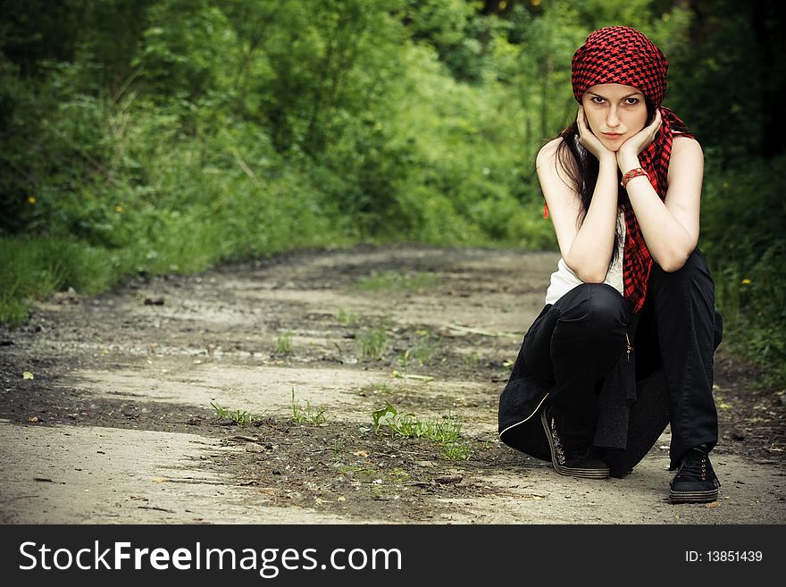 Girl sitting in the forest, on his head wearing a red kerchief. Girl sitting in the forest, on his head wearing a red kerchief