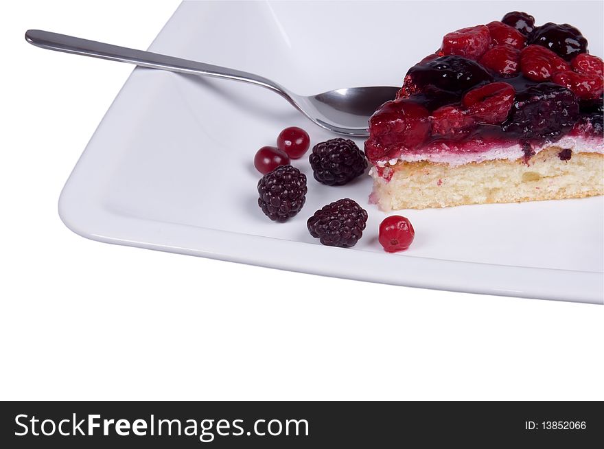 Piece of cake on the plate with a spoon isolated over white