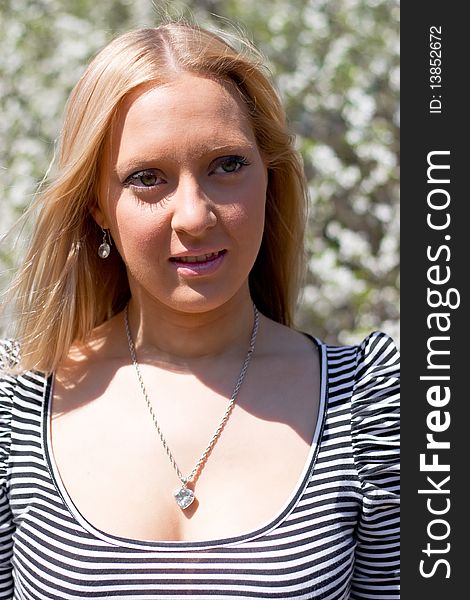 Blond girl in front of blossomed tree on early spring