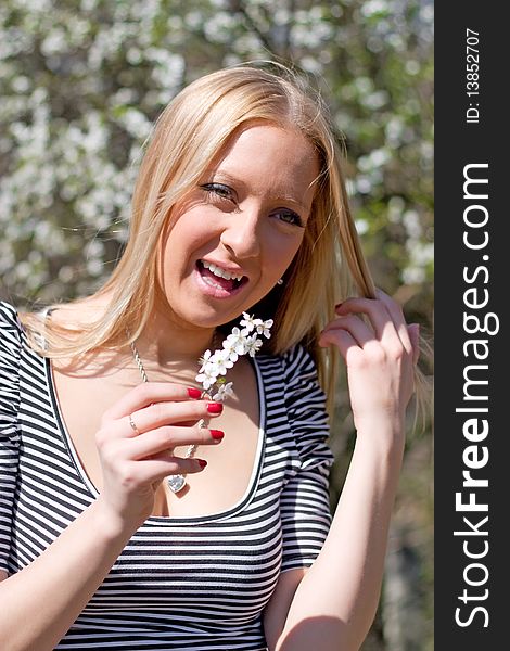 Blond girl in front of blossomed tree on early spring