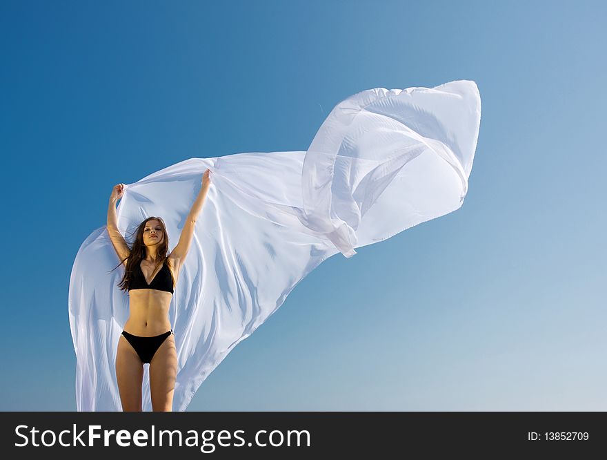 Young beautiful woman standing with white material. Young beautiful woman standing with white material