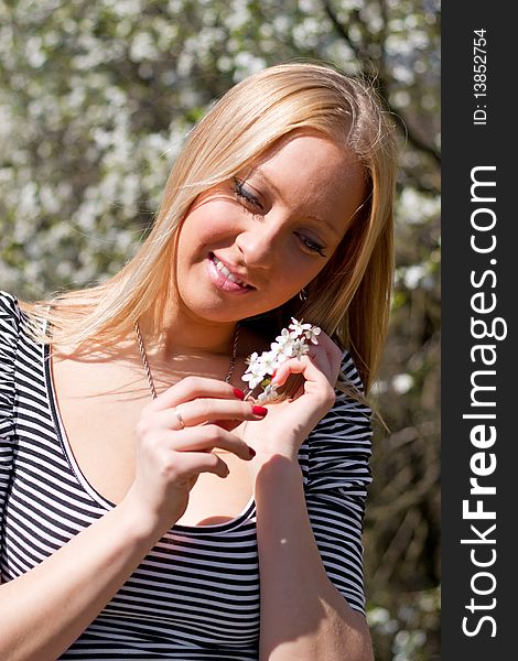 Blond girl in front of blossomed tree on early spring