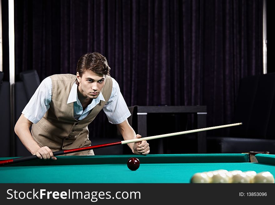 The young attractive well dressed man plays billiards. The young attractive well dressed man plays billiards