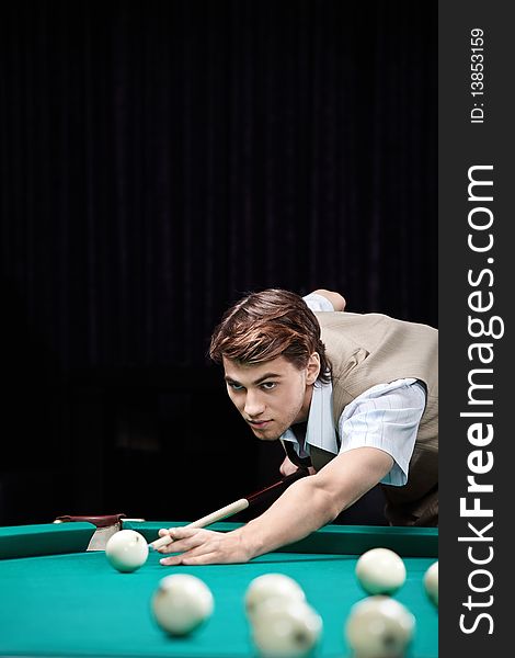 The young attractive well dressed man plays billiards. The young attractive well dressed man plays billiards