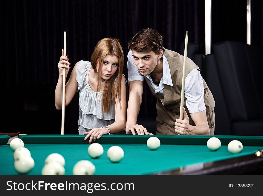 Young man and the woman play billiards. Young man and the woman play billiards