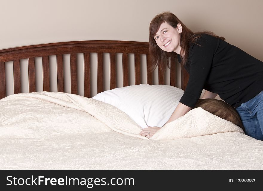 Brunette Woman Makes The Bed