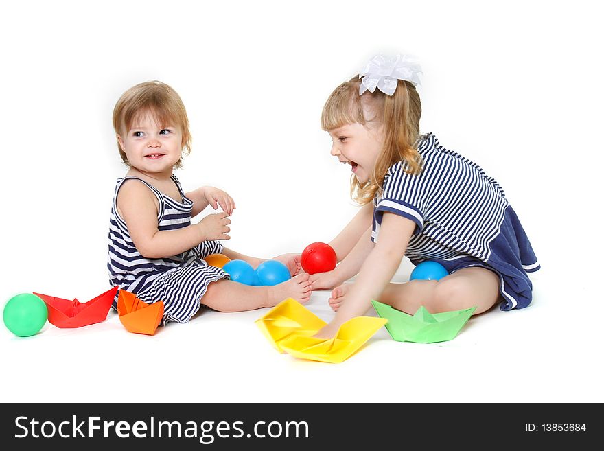 Two cute young sisters playing over white