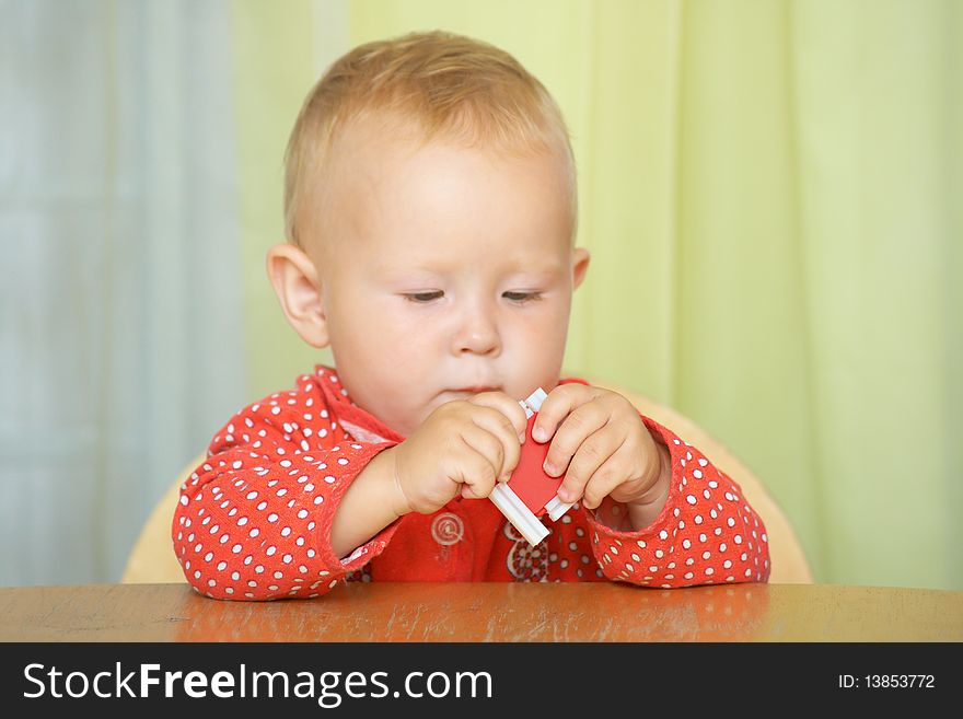 A small child plays with the constructor, sitting at the table. Focus on the hands. Shallow DOF.