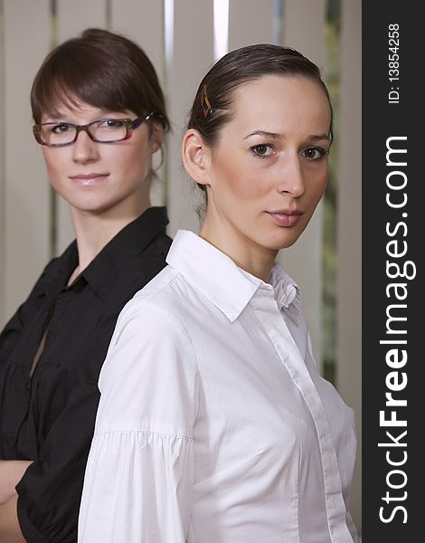 Two young businesswomen standing in the office. Two young businesswomen standing in the office