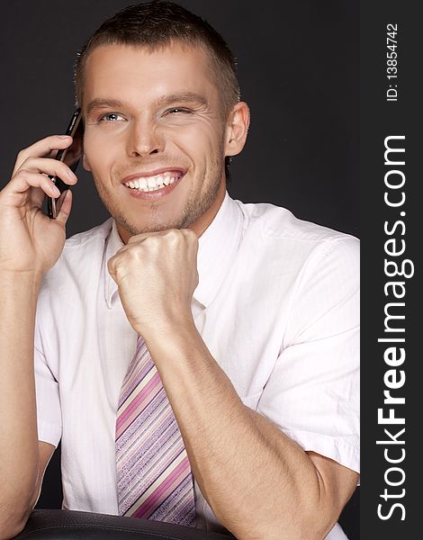 Happy young businessman with a mobile phone