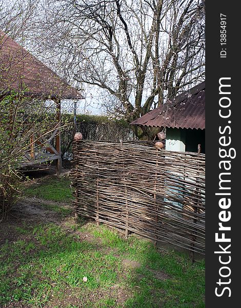 Country houses and wattle-fence with pots. Country houses and wattle-fence with pots