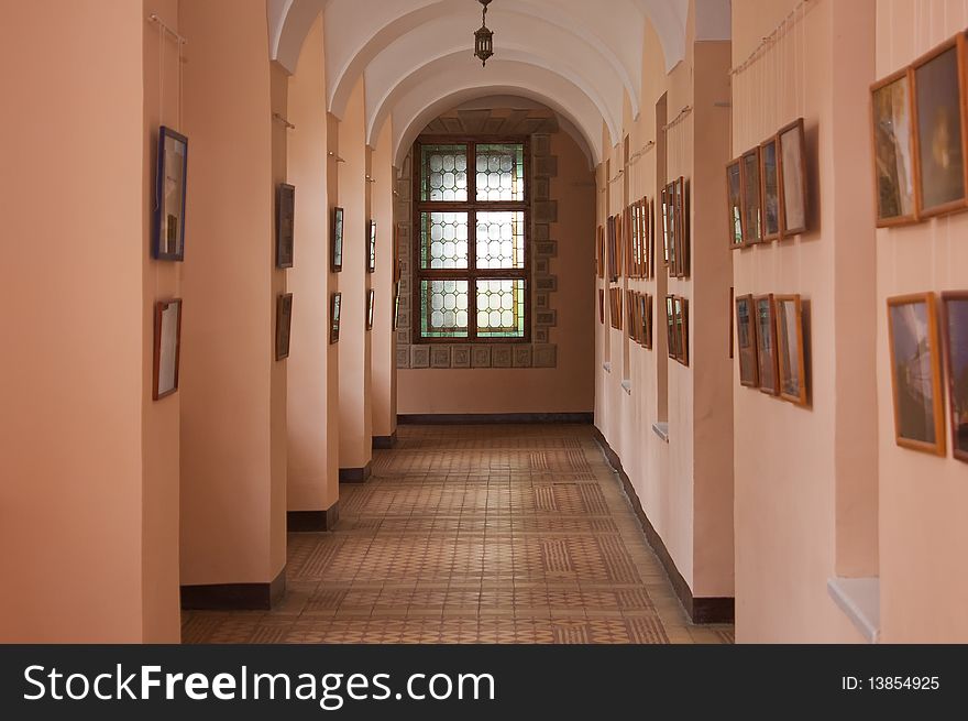 Ancient castle arcade with pictures on the walls and stained-glass window. Ancient castle arcade with pictures on the walls and stained-glass window