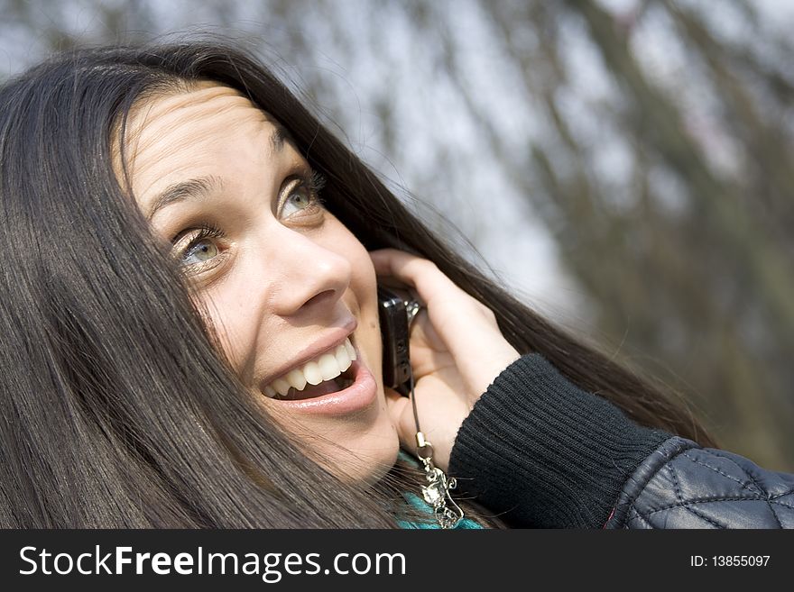 Young beautiful woman on the phone in the park. Young beautiful woman on the phone in the park