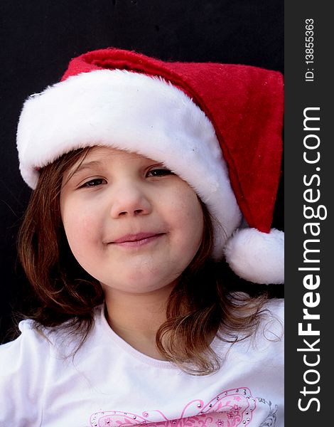 Little girl with red Santa hat on, smiling and happy. Little girl with red Santa hat on, smiling and happy
